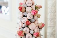 a lovely Valentine wedding cake of blush macarons, meringues and pink roses is gorgeous