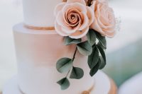 a lovely ombre blush wedding cake with pink and white sugar blooms, faux greenery and a glitter cake topper will do for a spring or summer wedding