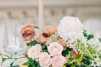 a lush Valentine wedding centerpiece of peachy, pink and white blooms and greenery is adorable and chic