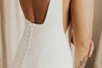 a minimalist plain sheath wedding dress with a cutout back on buttons looks wow