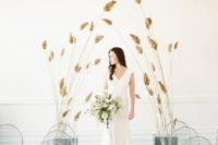 a minimalist wedding ceremony space with clear chairs and soem dried herbs for creating an altar