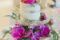 a naked wedding cake served with hot pink blooms and greenery is adorable for Valentine’s Day