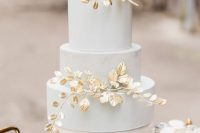 a pastel blue buttercream wedding cake decorated with gilded foliage is a gorgeous and elegant idea for a refined spring wedding