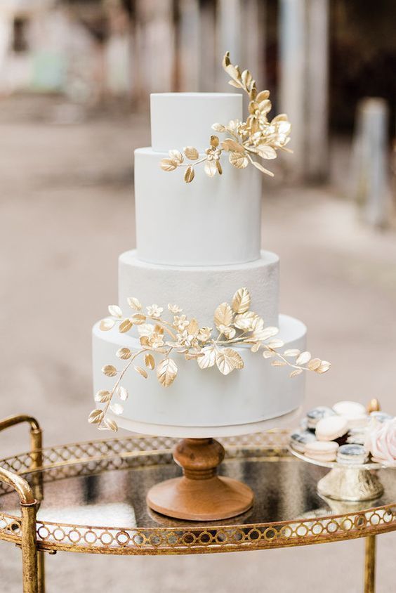 a pastel blue buttercream wedding cake decorated with gilded foliage is a gorgeous and elegant idea for a refined spring wedding