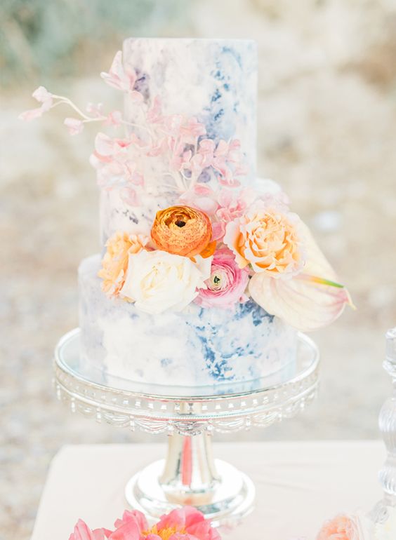 a pastel blue watercolor wedding cake decorated with pink, orange, peachy and blooming branches is cool for spring and summer