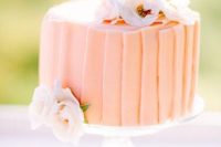 a peachy shard wedding cake decorated with white and blush blooms for a Valentine’s Day