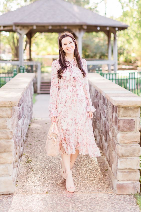 a pink floral midi dress with a high neckline, ruffles, long sleeves, nude shoes and a nude bag