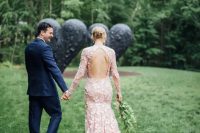 a bride in a trendy pink wedding dress and a groom in a blue suit