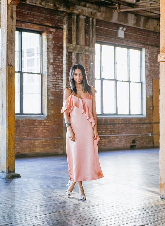 a pink spaghetti strap midi dress with ruffles, a statement bracelet and white shoes