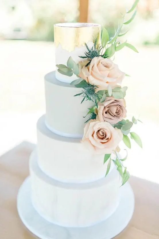 a powder blue wedding cake with gold leaf decor and blush roses and thistles is a very elegant choice