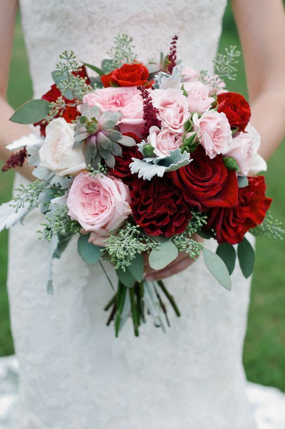 a romantic and chic Valentine wedding bouquet with deep red roses, pink and blue ones plus succulents and eucalyptus
