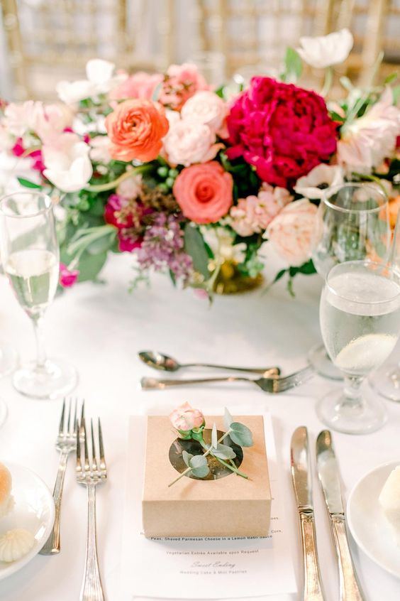 a romantic and chic Valentine's Day wedding tablescape with silver cutlery, bold blooms in blush and fuchsia, glasses and white porcelain
