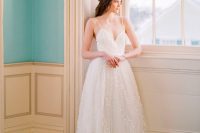 a romantic white A-line wedding dress with fabric petals, a heart neckline and spaghetti straps for a chic look