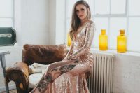 a rose gold sequin A-line wedding dress with long sleeves, a deep neckline, a side slit and a train will make a statement