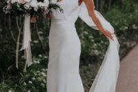 a sheath slip plain wedding dress and a veil for a chic minimalist bridal look