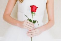 a single red rose used instead of a usual wedding bouquet is a lovely and chic idea for a Valentine bride
