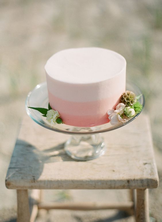 a sleek white and pink color block wedding cake decorated with white blooms and greenery for a modern Valentine wedding