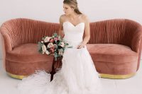 a strapless lace mermaid wedding dress with a feathered skirt and a train is a fabulous and amazing option for a Valentine’s Day