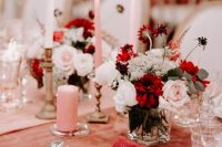 a stunning and catchy Valentine’s Day wedding table with a peachy tablecloth and a pink runner, pink candles, blush and burgundy blooms
