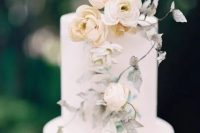 a subtle wedding cake in white, with neutral blooms and spray painted leaves is a very chic and beautiful idea for a neutral spring wedding