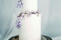 a subtle white buttercream wedding cake topped with lilac blooms is an amazing idea for spring celebrations with a pastel color palette