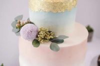 a tender ombre blue and pink wedding cake with gold foil, berries, foliage and lilac blooms on top is amazing for a spring wedding