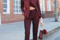 a total burgundy look with a twisted crop top, high waisted pants, a blazer, a bag, sheer shoes