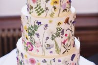 a white buttercream wedding cake with lots of pressed bright blooms is amazing for a spring or summer widlflower wedding