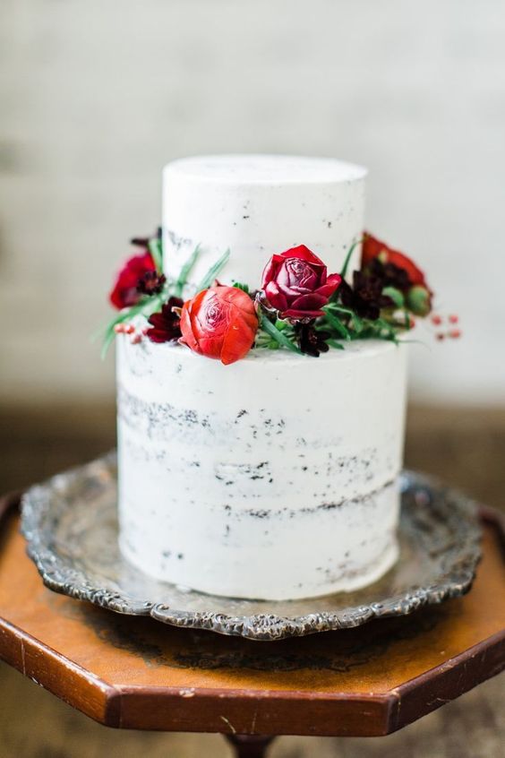 a white wedding cake decorated with red, burgundy and deep purpel blooms is an elegant and chic Valentine idea