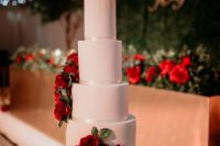 a white wedding cake decorated with red roses is timeless classics that brings much romance and elegance