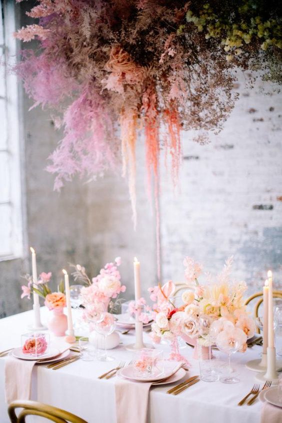 an ethereal and romantic Valentine's Day wedding table with blush blooms, grasses, candles, blooms as favors and a dried bloom and berry installation