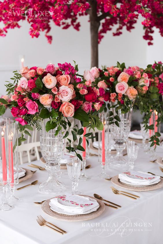 an exquisite Valentine's Day wedding tablescape in neutrals, with bold floral arrangements, pink candles and gold cutlery