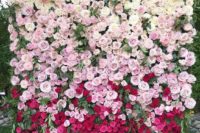 an ombre floral wall fro white to light pink and fuchsia plus textural greenery is a trending idea