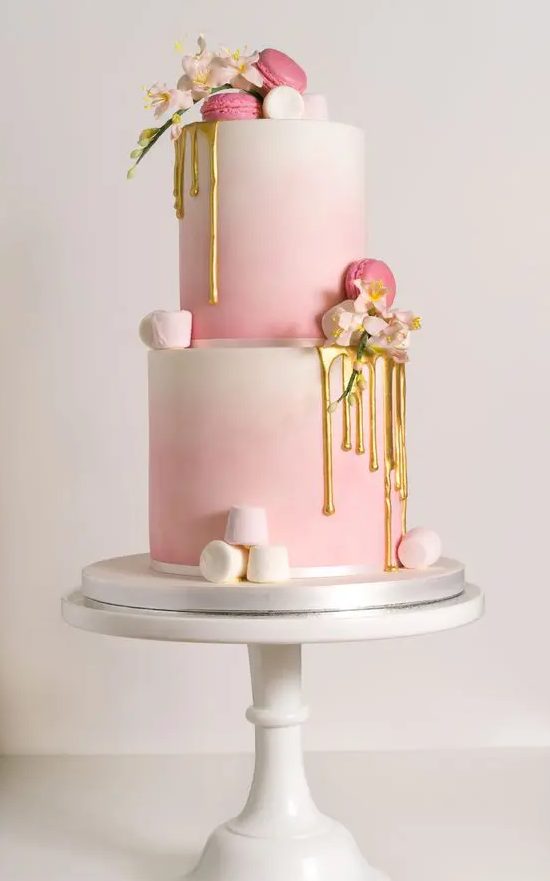 an ombre pink wedding cake with marshmallows, gold drip and macarons for a cute glam wedding