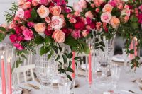 bold Valentine wedding centerpiece of light pink, fuchsia, peachy and red blooms and greenery is fantastic