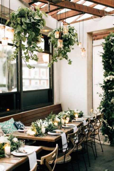 cascading greenery hangings plus some lanterns and matching centerpieces for a homey feel in your reception