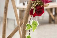 decorate the wedding chairs with red roses, blooming branches and greenery to make them look very refined and very chic