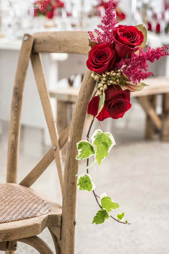decorate the wedding chairs with red roses, blooming branches and greenery to make them look very refined and very chic