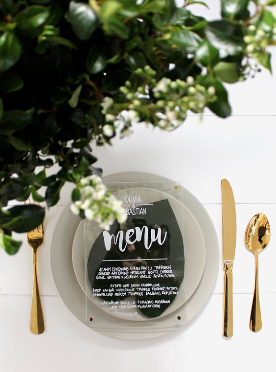 greenery, matte grey dishes and an acrylic menu for a chic minimalist look with a shiny touch