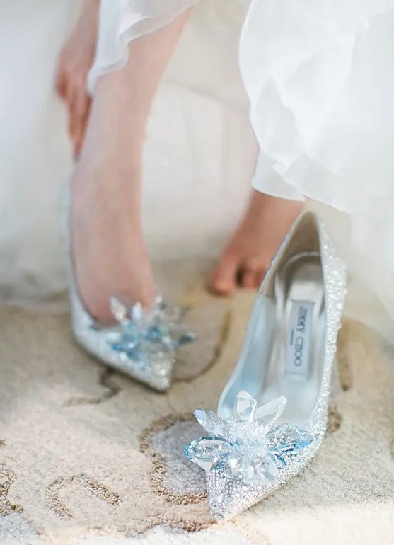 super shiny silver wedding shoes fully covered with rhinestones and with oversized blue rhinestone flowers are a very glam solution
