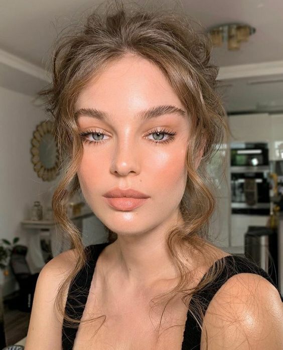 trendy wedding makeup with an accent on the dewy skin, with a matte blush lip, a bit of blush on the cheeks and forehead, mascara and accented eyebrows
