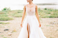 a beautiful A-line wedding dress with an illusion neckline and a beaded bodice, a layered skirt with a slit