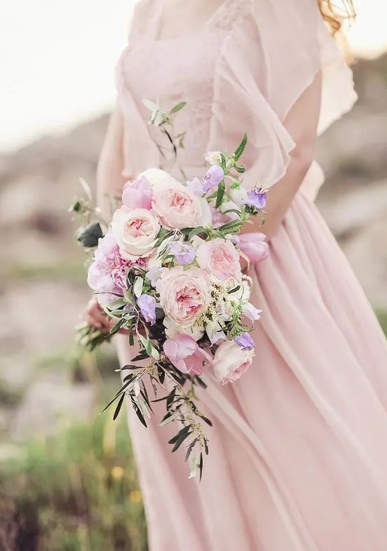 a beautiful and chic blush wedding bouquet of peony roses and some cascading greenery is a beautiful idea to rock