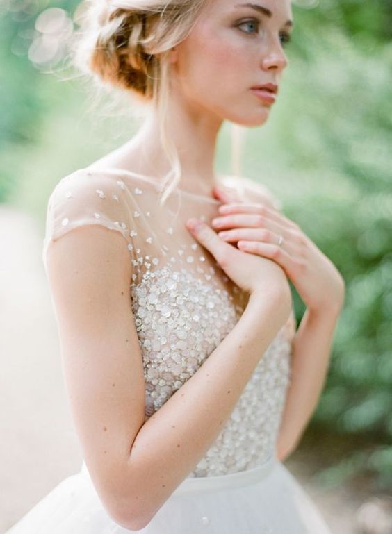 a beautiful sparkling wedding dress with an illusion neckline, cap sleeves and a tulle embellished skirt is wow