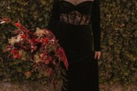 a black velvet wedding dress with an illusion neckline and a lace insert, statement earrings and a chic updo for a Halloween wedding