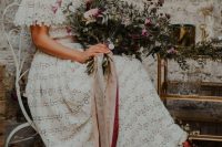 a boho lace off the shoulder wedding dress with a silk sash and a statement necklace plus sneakers