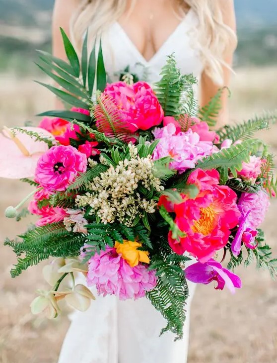 a bright tropical wedding bouquet with hot pink blooms, ferns and greenery, some blush tropical blooms and berries is amazing