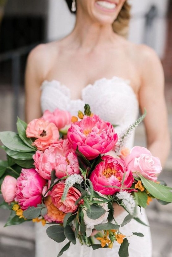 a bright wedding bouquet of pink and hot pink peonies and greenery, yellow blooms and astilbe is a fun idea for a summer bride