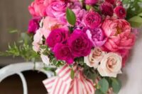 a bright wedding bouquet of pink, hot pink and fuchsia blooms, greenery and striped ribbons is a fantastic solution