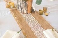 a burlap and lace table runner, a centerpiece of a tree stump with blooms, greenery and evergreens is a lovely idea for a wedding